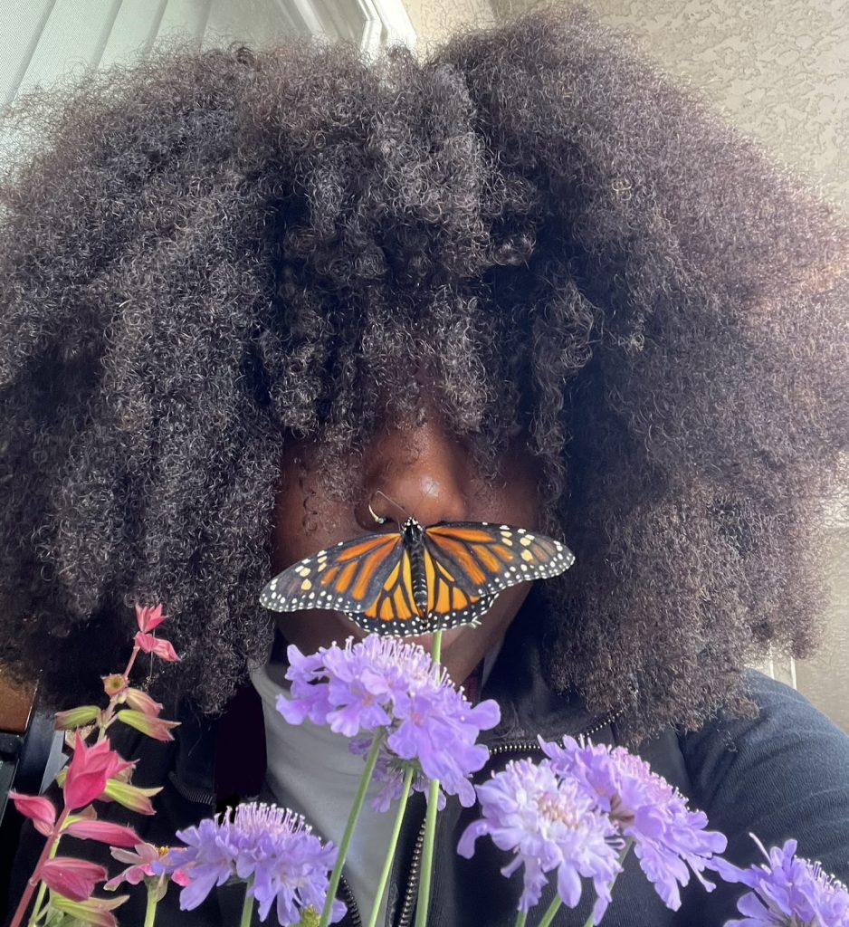 Picture of Ogechi with a Monarch butterfly